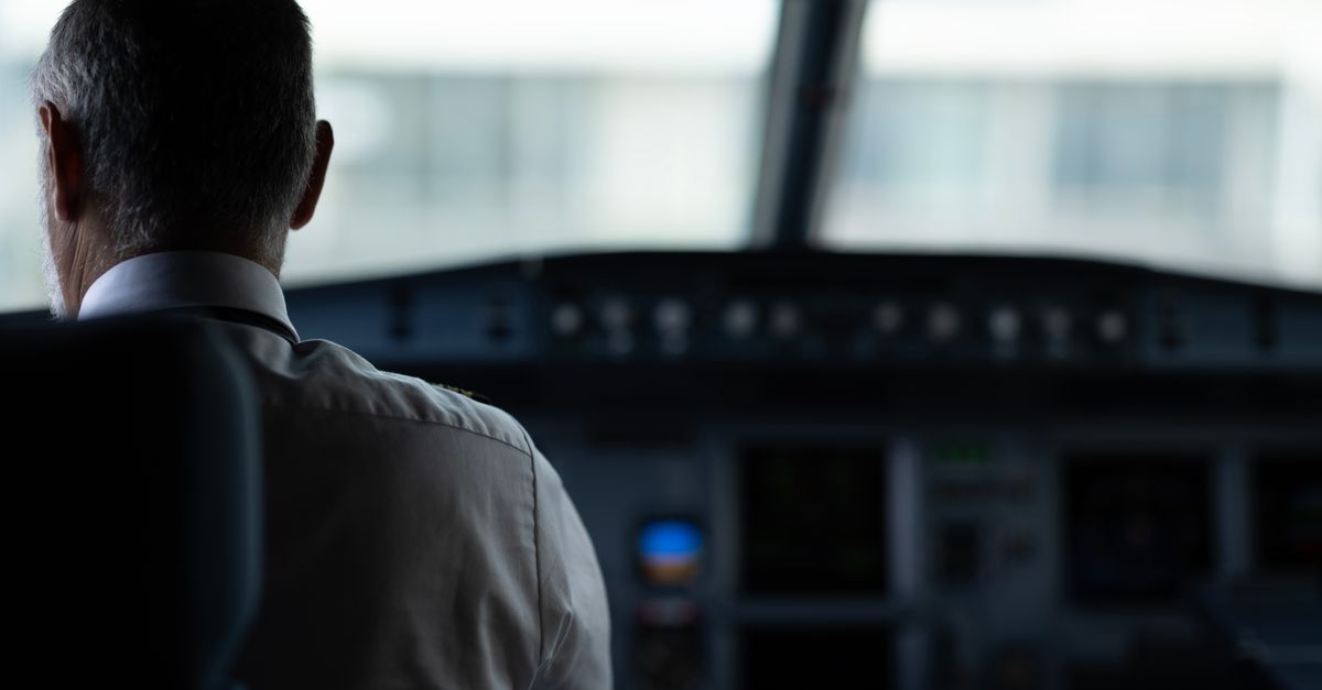 A focused view of an airline pilot in the cockpit, emphasizing responsibility and aviation control.